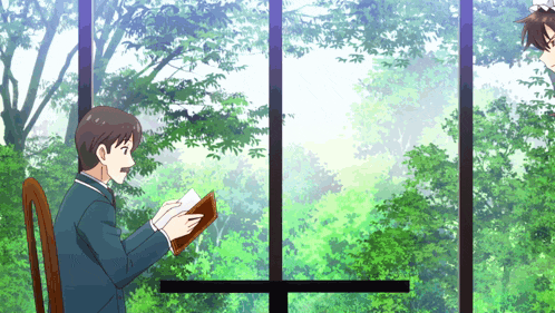 a man is reading a book in front of a window