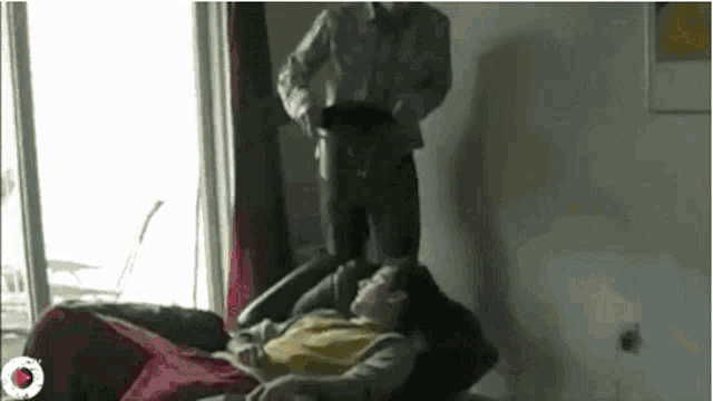 a man is standing next to a woman laying on a chair .