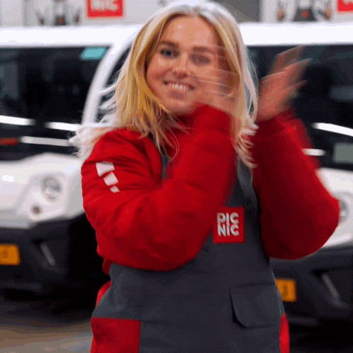 a woman wearing a red jacket and an apron that says picnic