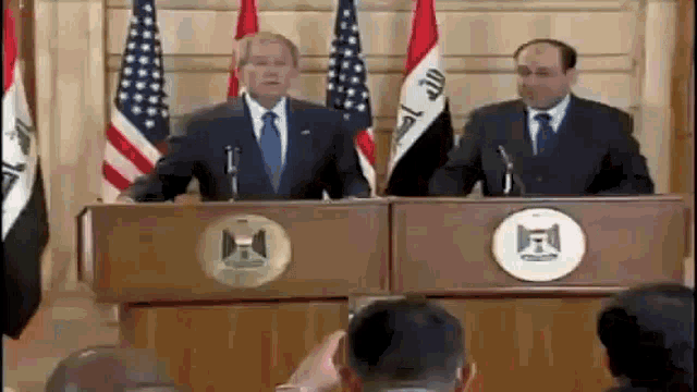 a man in a suit and tie is giving a speech at a podium .
