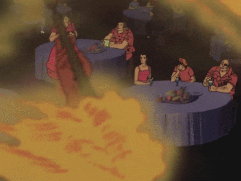 a group of people sitting at tables with a fire coming out of the middle of the room