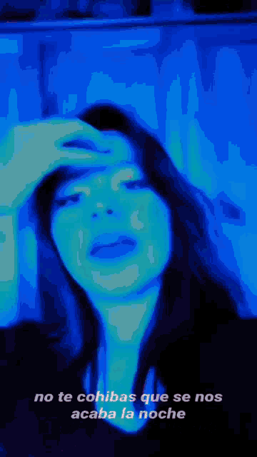 a blurry photo of a woman with the words no te cohibas que se nos acaba la noche on the bottom