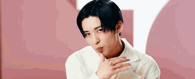 a young man in a white shirt is making a face