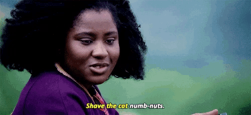 a woman in a purple sweater is saying shave the cat numb nuts