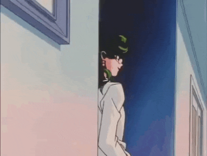 a woman is standing in a hallway next to a window .