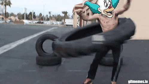 a man with a clown face on his chest is holding a tire