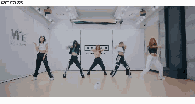 a group of women are dancing in front of a sign that says wine entertainment