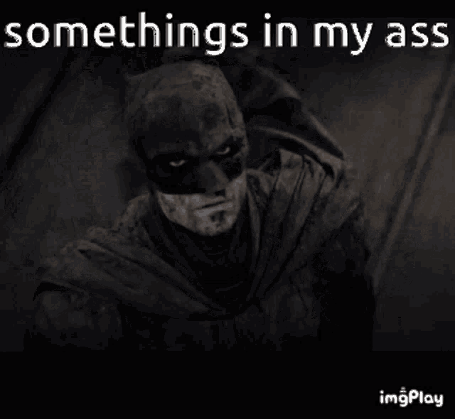 a black and white photo of batman with the words somethings in my ass above him