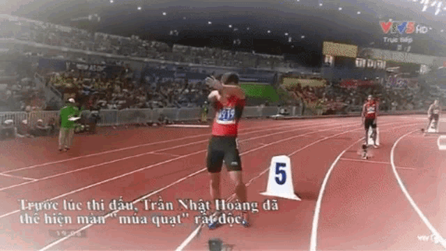 a runner on a track with the number 5 in front of them