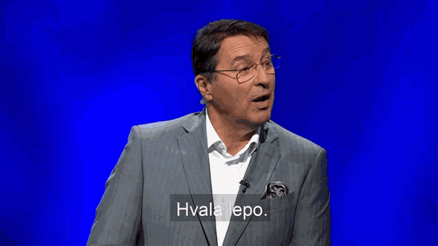 a man in a suit and glasses says hvala lepo