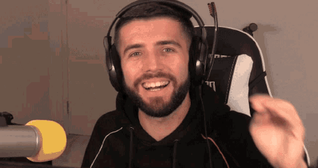 a man with a beard wearing headphones and a microphone in front of him
