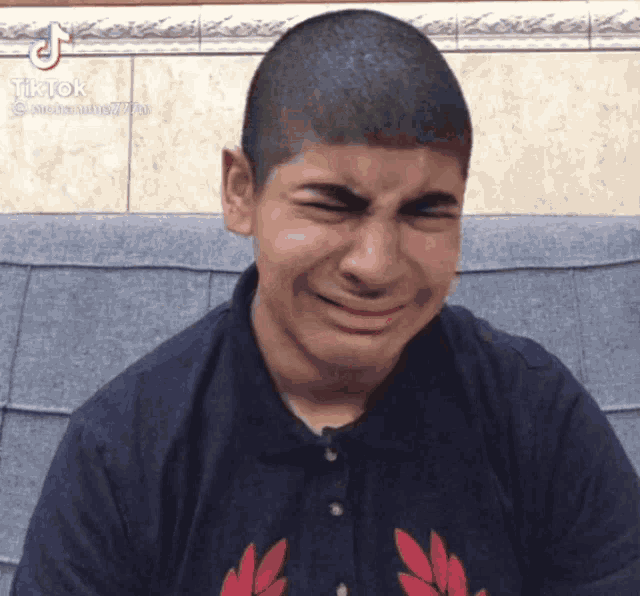 a young man with a shaved head is making a funny face with a tiktok logo in the corner