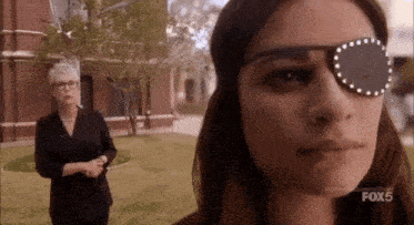 a woman wearing glasses stands next to a woman wearing a blindfold with the fox 5 logo in the corner
