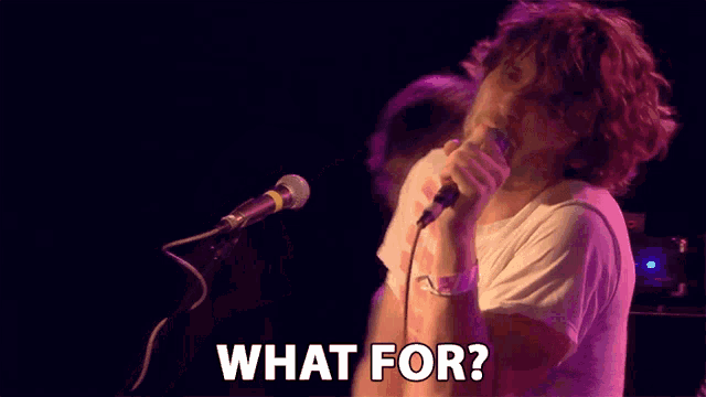 a man singing into a microphone with the words what for written below him