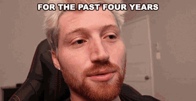 a man with a beard is sitting in a chair with the words " for the past four years " above his head