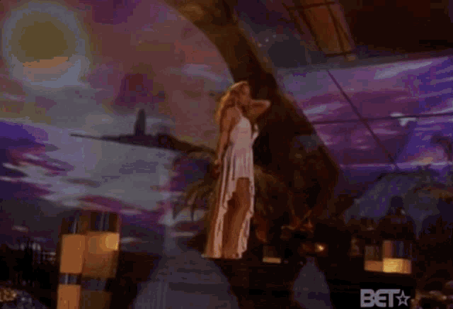 a woman in a white dress with a plunging neckline is dancing on a stage .
