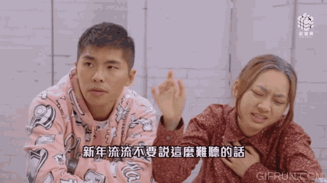 a man and a woman are sitting in front of a brick wall and a gif from gifrun.com