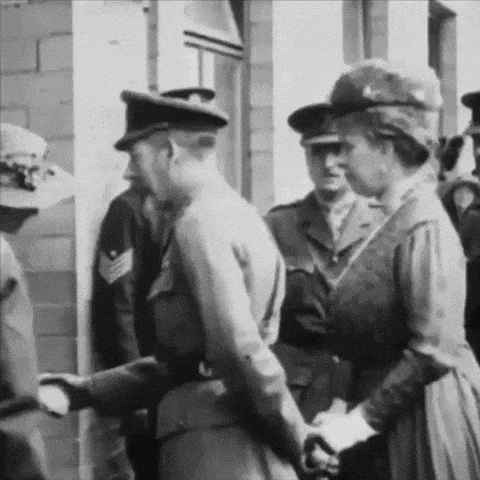 a black and white photo of a woman shaking hands with a man in uniform