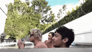 a group of young men are sitting in a hot tub