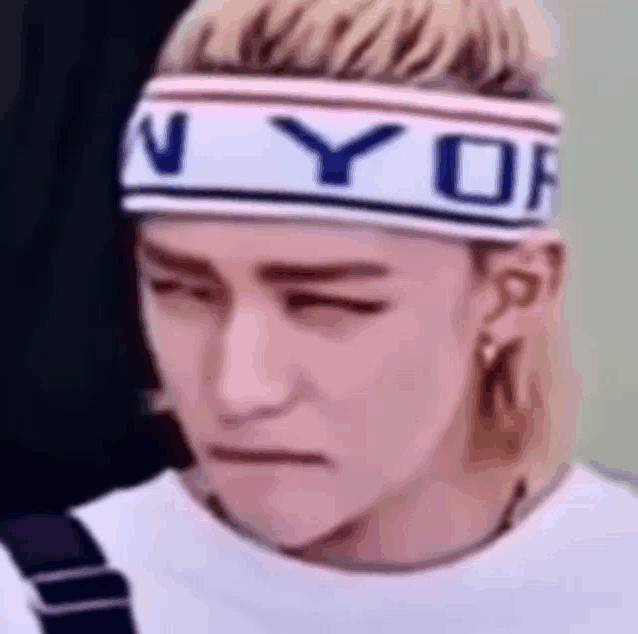 a close up of a person wearing a headband and making a face .