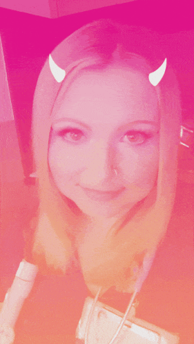 a woman with horns on her head is smiling for the camera