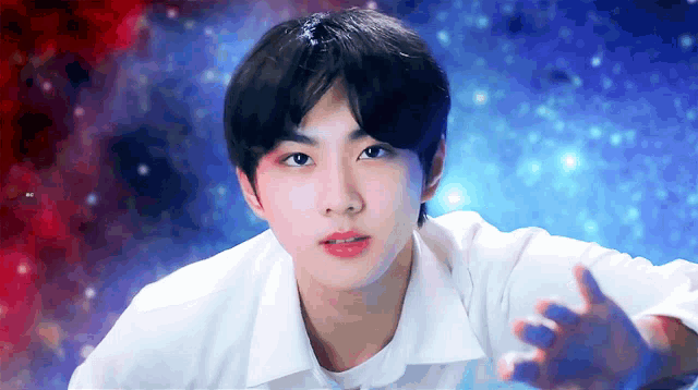 a young man in a white shirt is looking at the camera with his hands outstretched