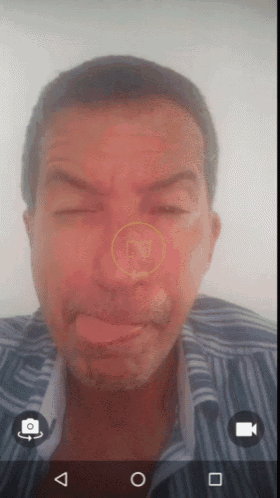 a man is making a funny face with a yellow circle around his nose