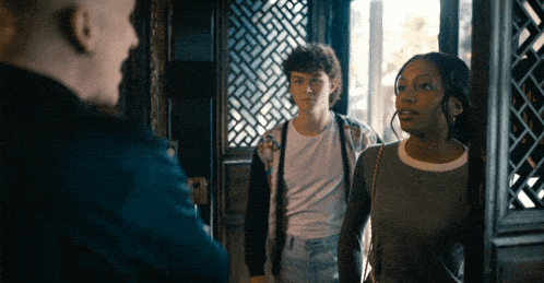 a man and two girls are standing in a doorway talking to each other