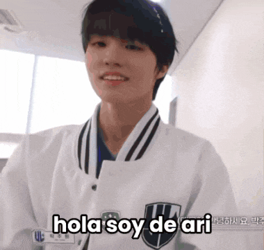 a young man wearing a white jacket with the words hola soy de ari on it