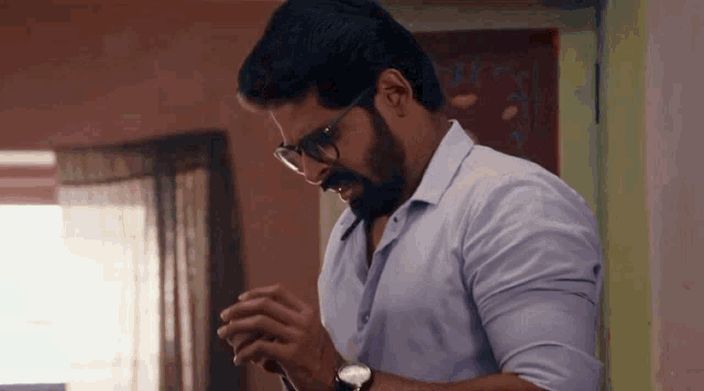 a man with glasses and a beard is praying