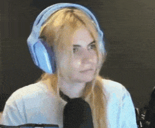 a woman is wearing headphones and a tie in front of a microphone .