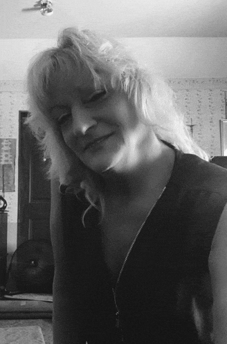 a woman with blonde hair wearing a black shirt with a zipper