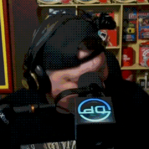 a man wearing headphones is talking into a microphone with a dp logo on it