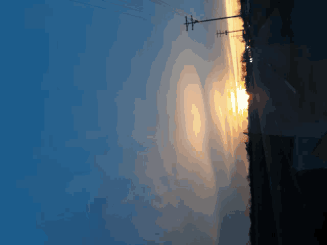 a sunset with a few power lines in the distance