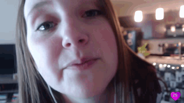a close up of a woman 's face with a pink heart in the corner