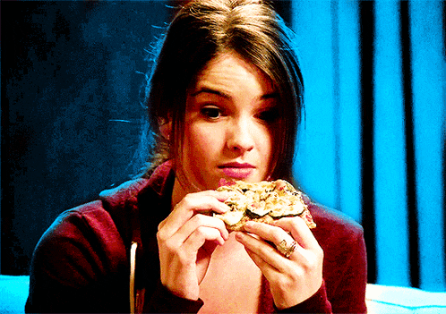 a woman with a ring on her finger eating a sandwich
