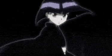 a girl in a kimono is holding a fan in her hand in a dark room .
