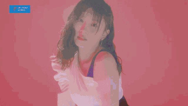 a girl is standing in front of a pink background with a blue sign that says up front world