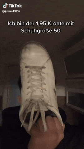 a person is holding up a pair of white sneakers with a tiktok watermark