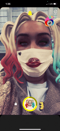 a woman wearing a harley quinn mask on a phone