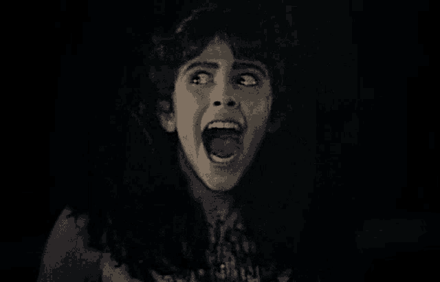 a woman is screaming with her mouth wide open