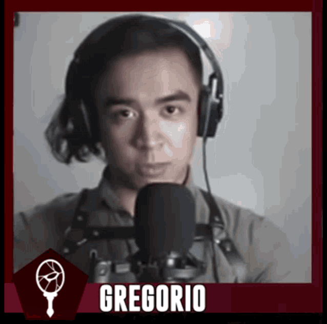 a man wearing headphones stands in front of a microphone with the name gregorio on the bottom right