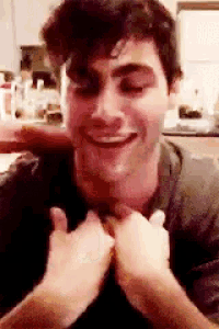 a close up of a man making a funny face with his hands on his chest .