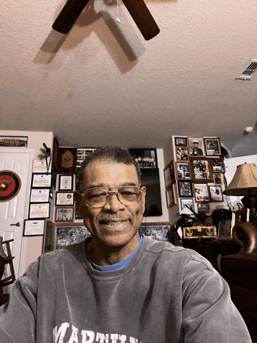 a man wearing glasses and a grey shirt that says martin on it