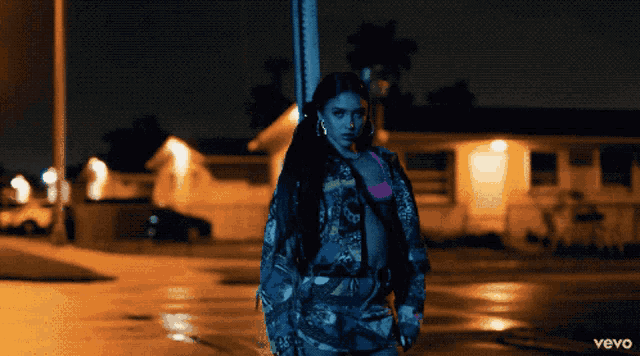 a woman is standing in front of a street sign that says vevo on it