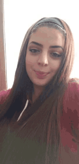 a woman with long hair wearing a headband smiles for the camera