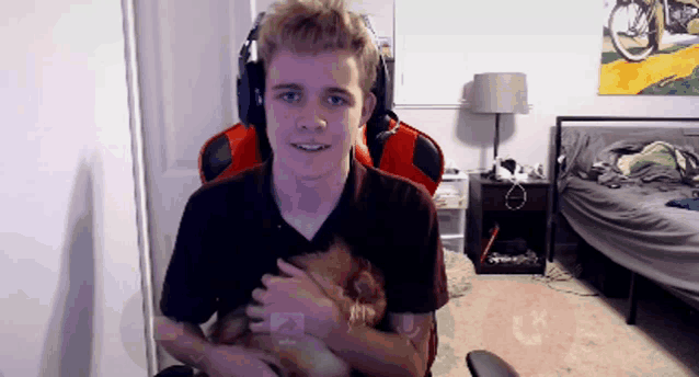 a man in a red chair is holding a small animal