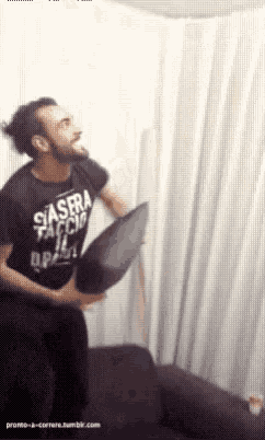 a man wearing a shirt that says siasera faccio brasil is holding a black pillow