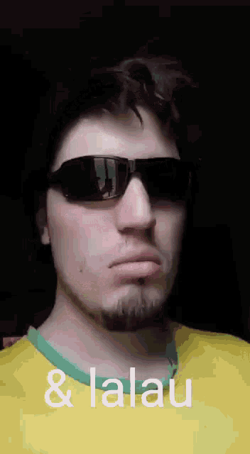 a man wearing sunglasses and a yellow shirt with the words & lalau written on it