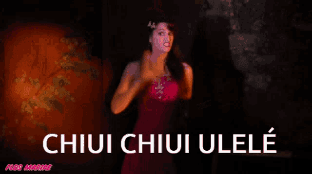 a woman in a pink dress is standing in front of a sign that says chiui chiui ulele